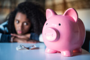 Sad frustrated black woman with piggy bank